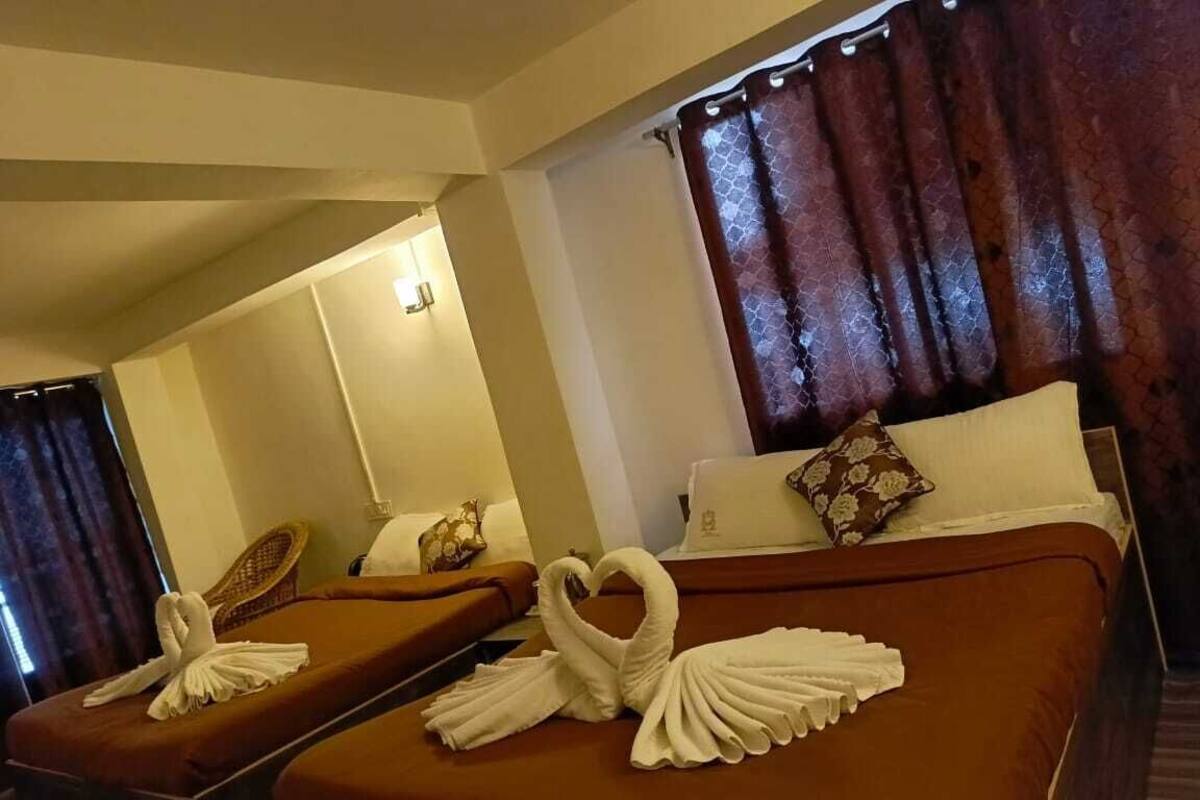 Ein Hotelzimmer mit zwei Betten, auf jedem liegt ein Handtuch in der Form eines Schwans.
