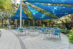 Relax in a serene garden setting with comfortable seating and shaded tables.
