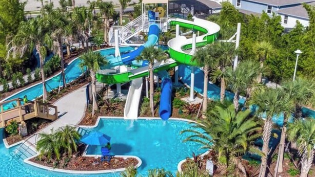 A water park with multiple slides and a central pool surrounded by palm trees. - Relax in Style with Private Pool, BBQ and More (Davenport)