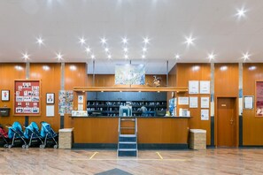 A reception area with a wooden counter, a ladder, and a wall with framed photos and certificates.