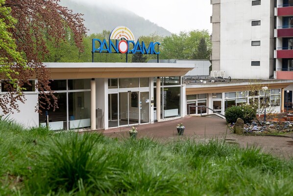 A modern building with a sign reading "PANORAMIC" and a glass entrance.