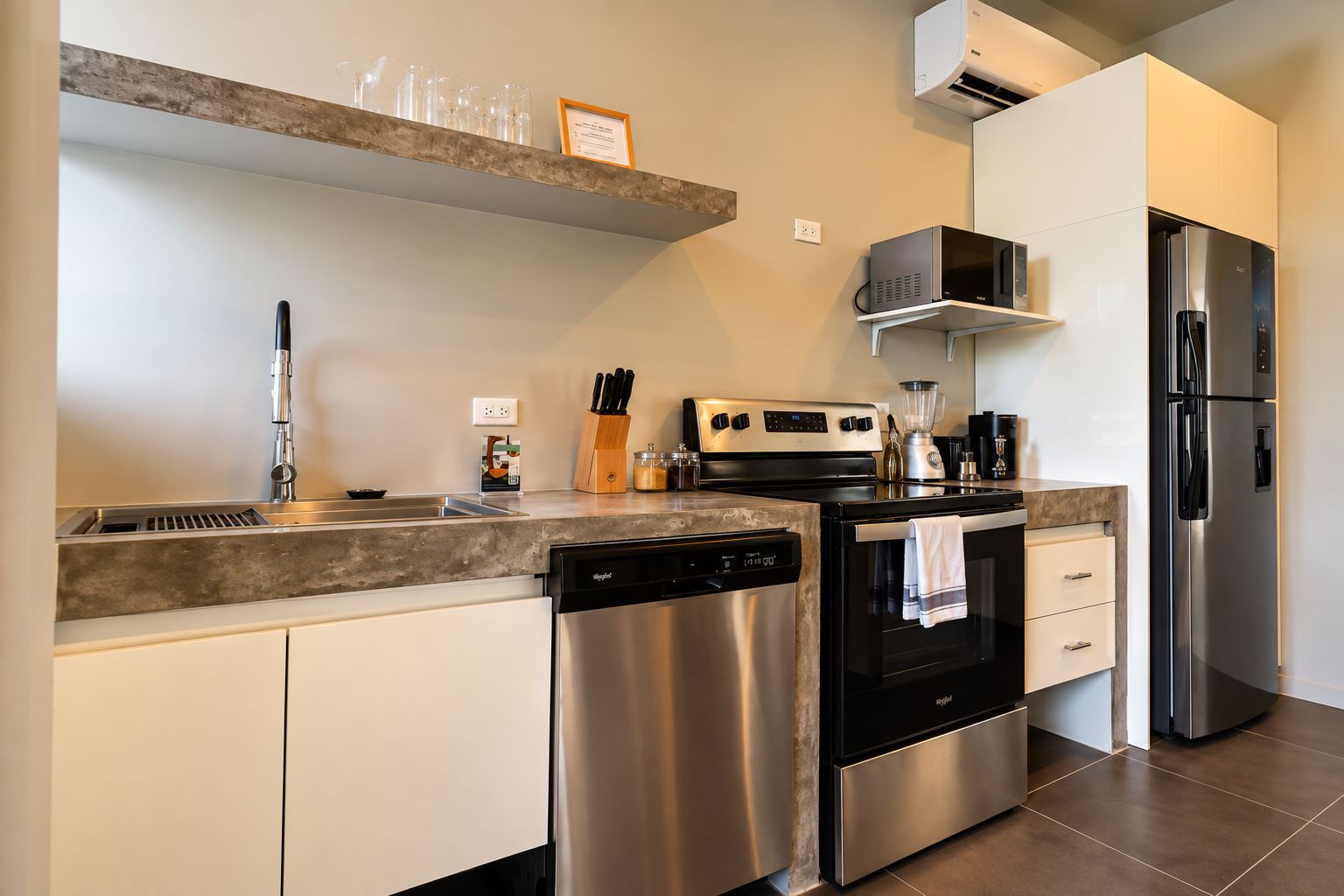 Una cocina moderna con electrodomésticos de acero inoxidable, lavavajillas y horno empotrado.