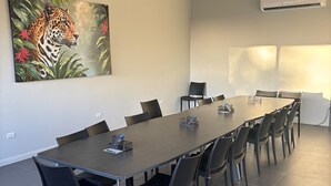 Ett konferensrum med ett långt bord, stolar, takfläktar och en luftkonditioneringsanläggning.