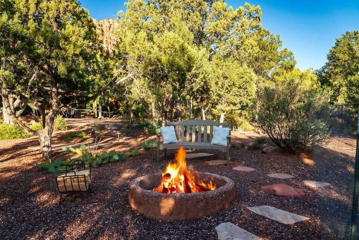 A fire pit surrounded by a bench and a walking path.