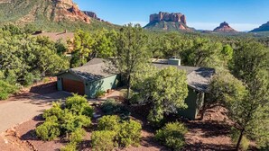 A remote cabin with a dirt driveway, surrounded by dense forest and red rock formations in the background. - NEW! Peaceful Sedona Gem (Sedona)