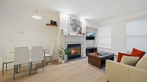 A modern living room with a fireplace, white furniture, and a tiger artwork on the wall. - Ballard Basecamp: Steps to ALL! (Telluride)