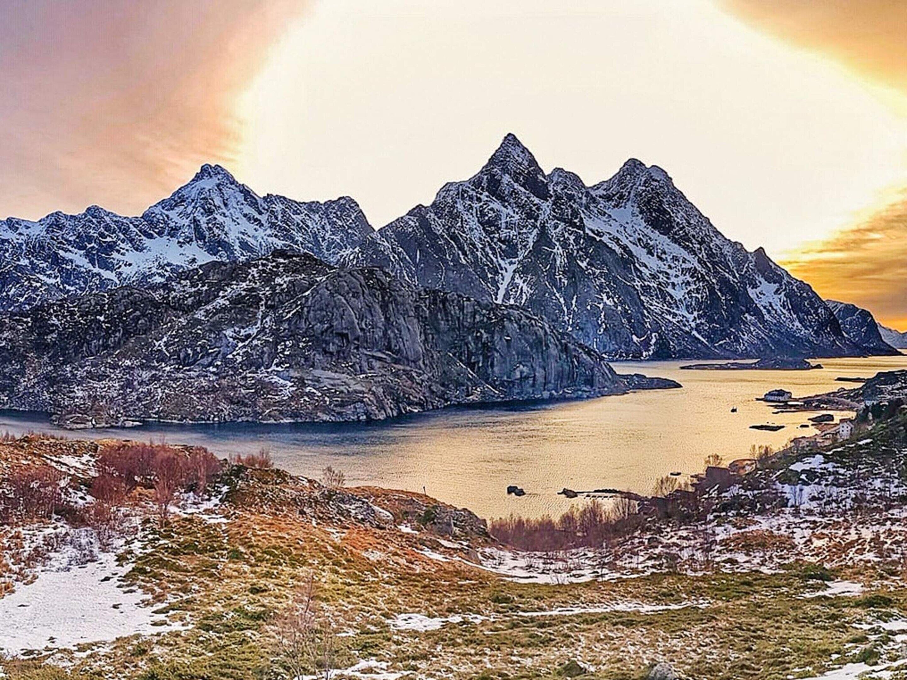 A mountainous landscape with a lake and a small settlement.