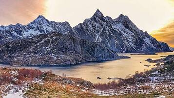 A mountainous landscape with a lake and a small settlement.