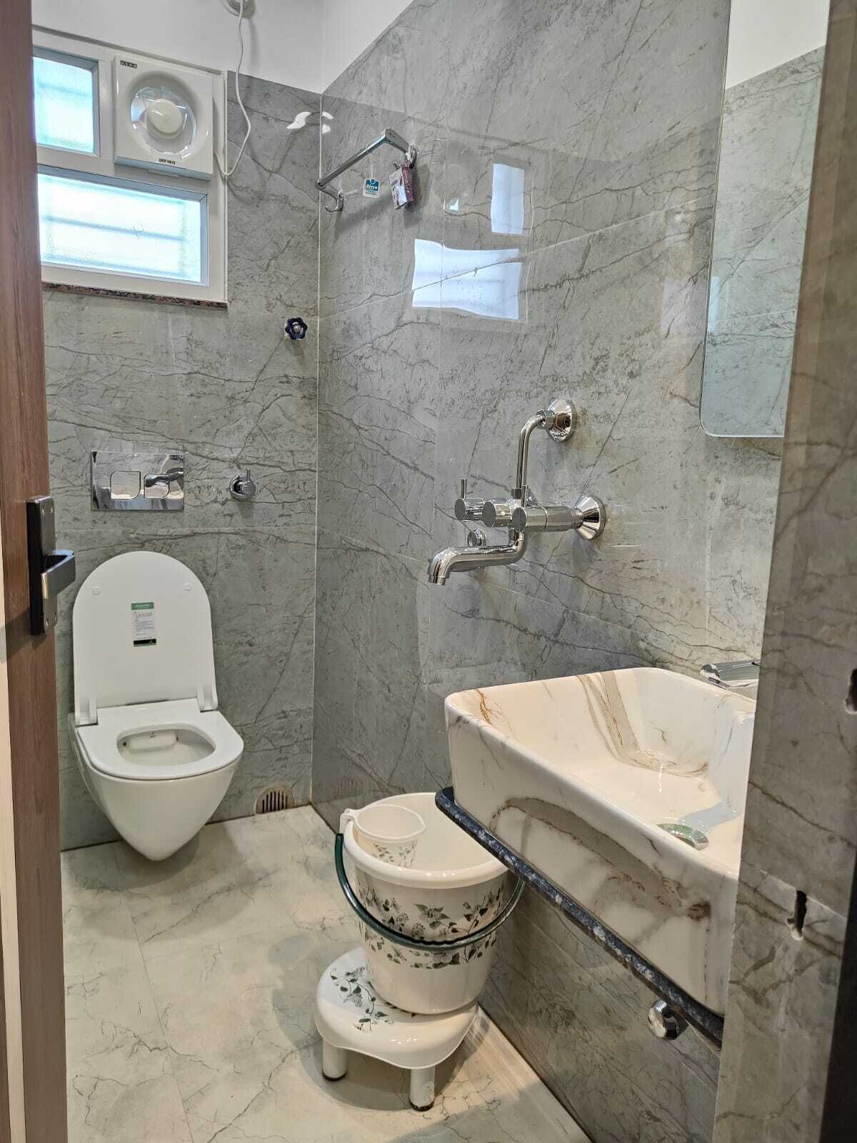 A bathroom with a toilet, bidet, and sink.