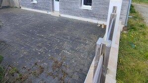 Un bâtiment à deux étages, doté d’une façade grise, de nombreuses fenêtres et d’une allée pavée.