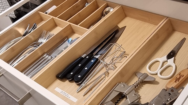 A kitchen drawer with utensils and tools.