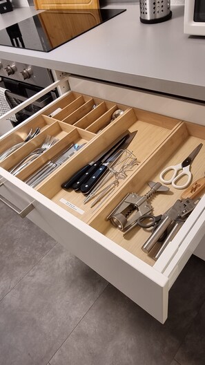 A kitchen drawer with utensils and tools.