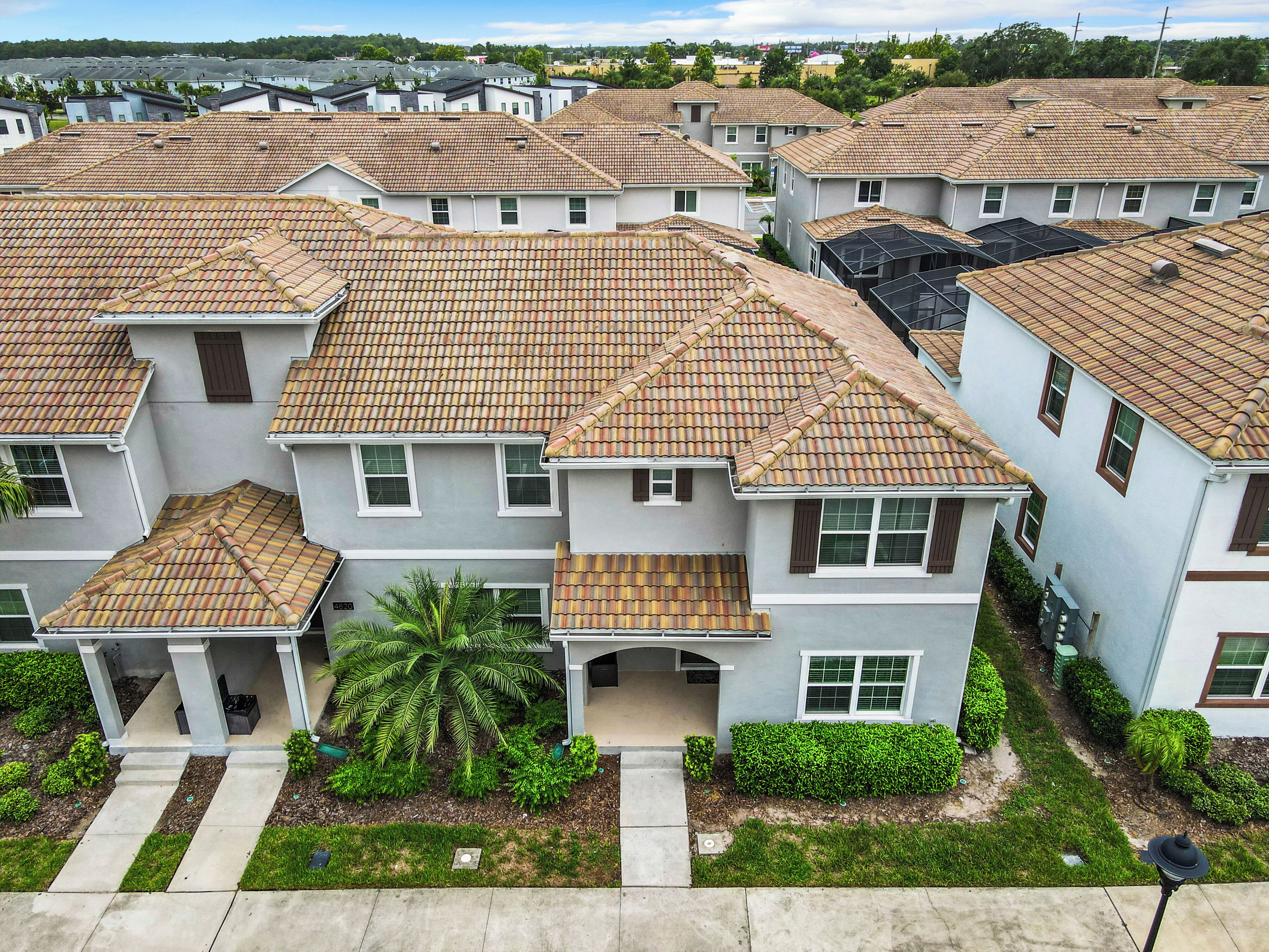 A residential area with multiple two-story houses featuring tiled roofs and white exteriors.
