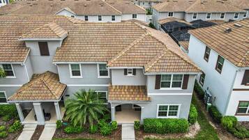A residential area with multiple two-story houses featuring tiled roofs and white exteriors.