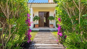 A pathway leading to a house with a tiled roof and a wooden door. - Luxury Villa - Sleeps up to 8 & Infinity Pool (Estepona)
