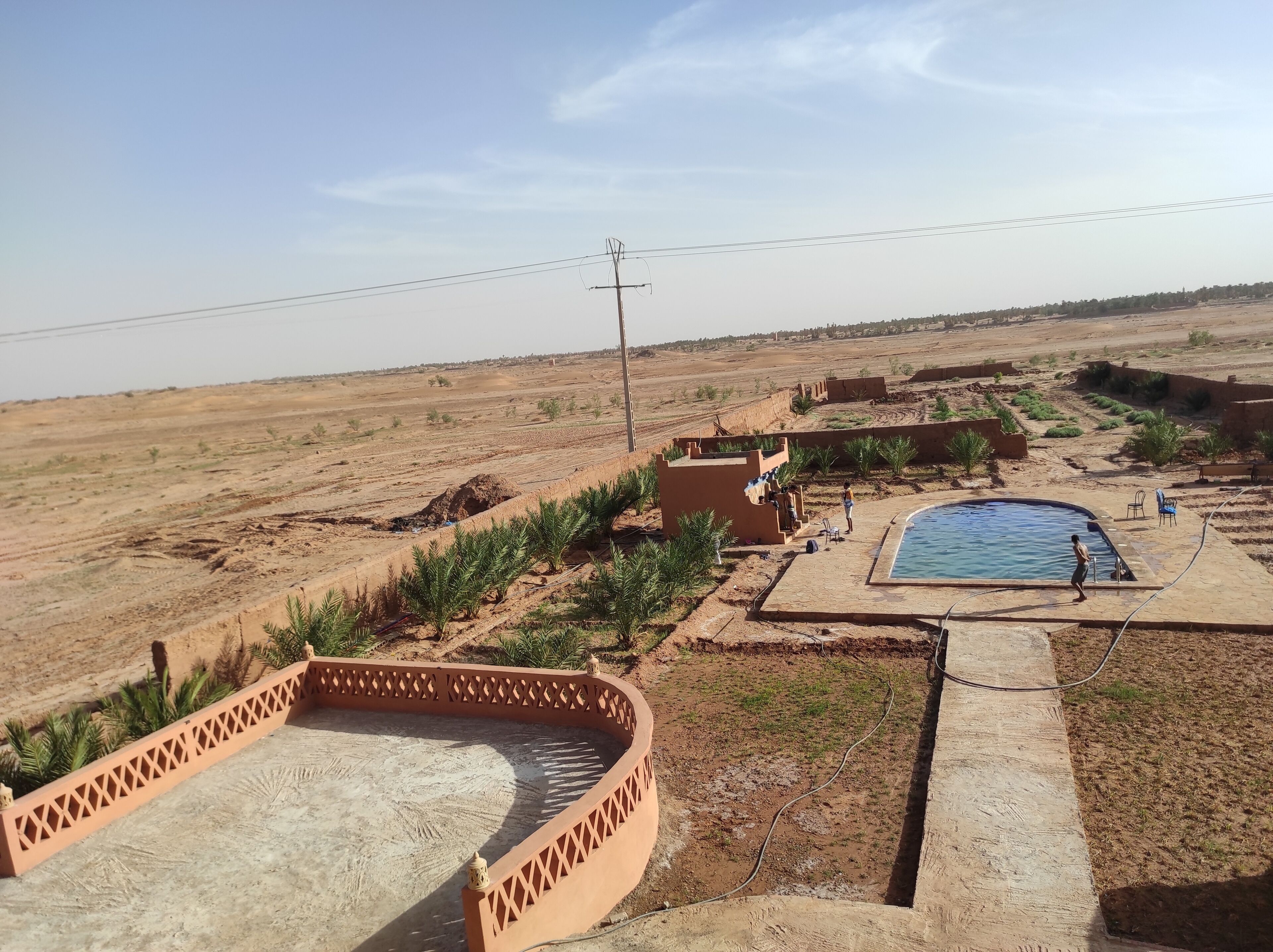 Un paysage désertique avec une piscine et un petit bâtiment.