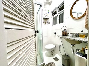 Chuveiro, toalhas de banho, sabonete, papel higiênico