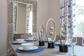 Enjoy meals in a stylish dining area with a beautifully set table and elegant mirror.