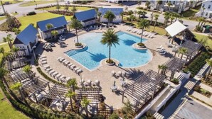 Ein Resort mit einem zentral gelegenen Pool, Liegestühlen und Palmen.
