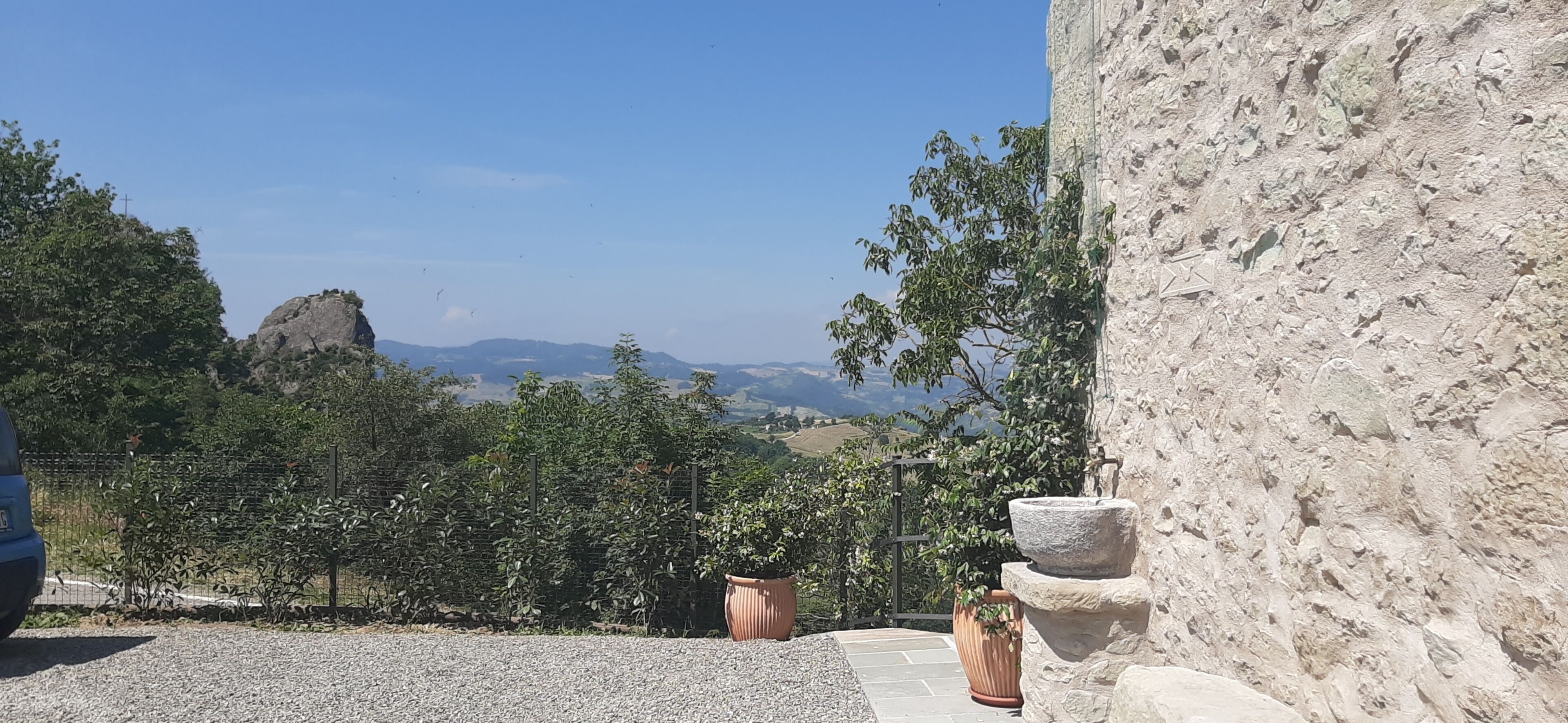 A stone building with a view of distant hills and a clear sky.