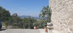 A stone building with a view of distant hills and a clear sky.