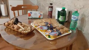 A round table with a variety of food items, including bread, nuts, and packaged snacks. - Il Castellaro ai Sassi (Guiglia)