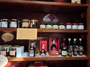 A variety of food products on shelves, including jars of preserves, bottles of olive oil, and boxes of pasta. - Il Castellaro ai Sassi (Guiglia)
