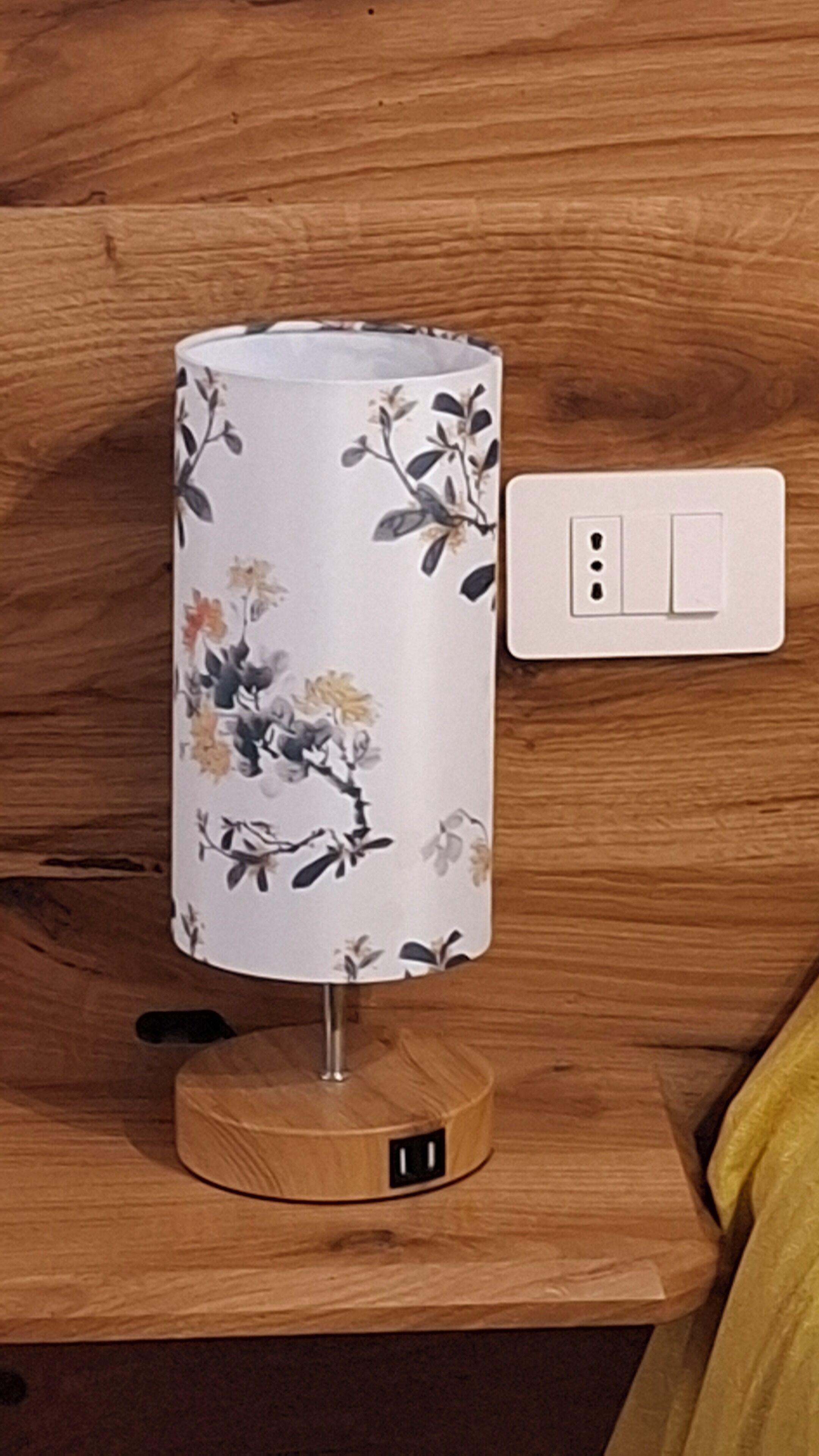Una lámpara con un estampado floral sobre una superficie de madera.