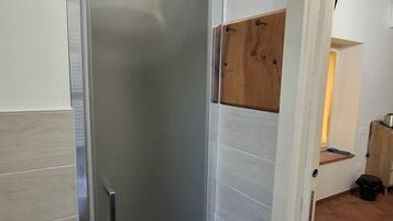 Una stanza con una porta scorrevole, pavimento in legno e parete bianca.