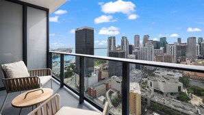 Ein Balkon mit Blick auf die Stadt, ein Stuhl und ein Tisch.