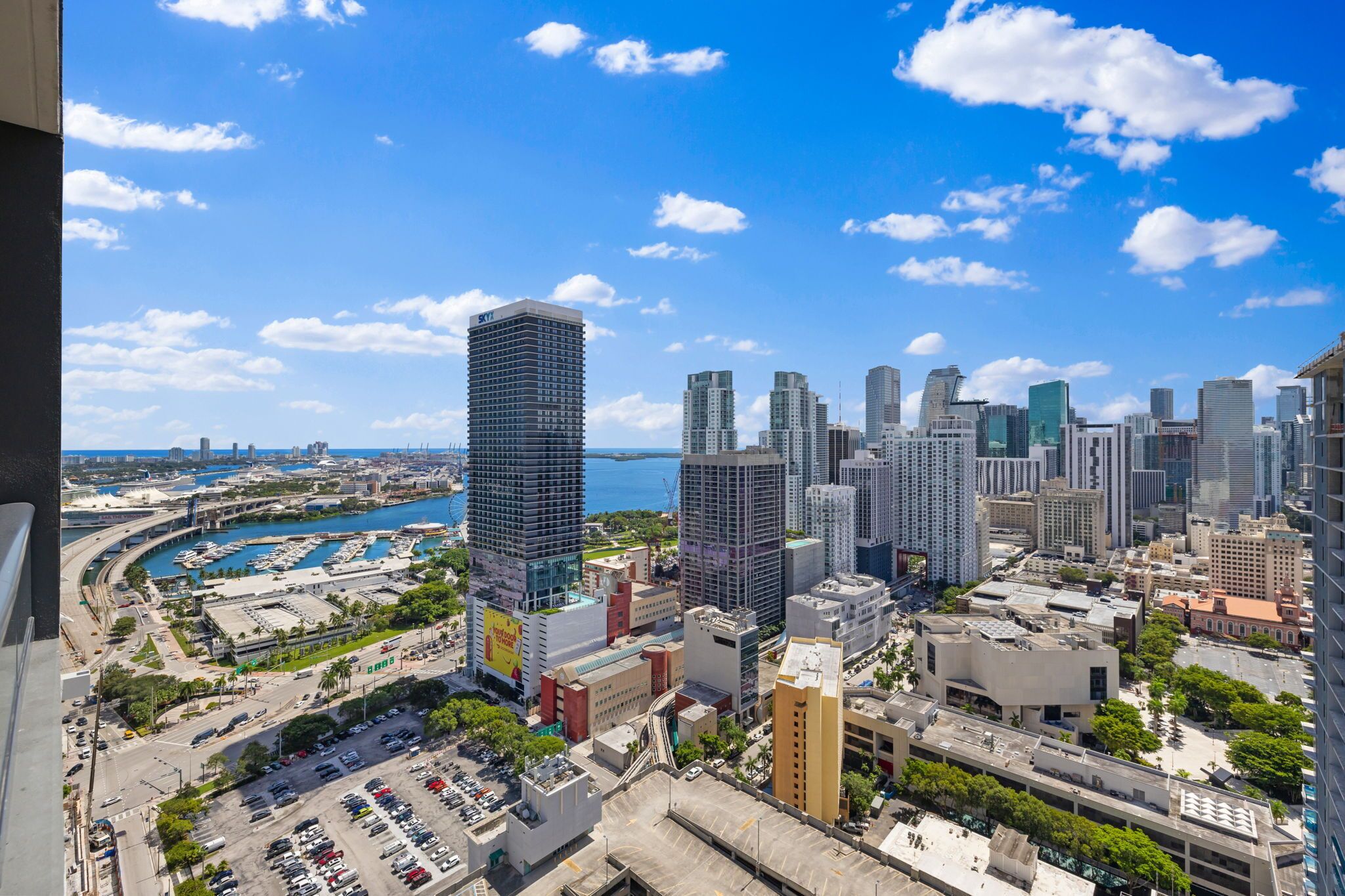 A cityscape with high-rise buildings, a marina, and a clear blue sky.