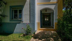 Une maison à deux étages avec un chemin de pierre menant à l’entrée.