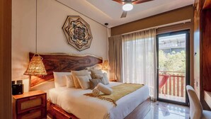 A bedroom with a large bed, a nightstand, a lamp, a ceiling fan, and a view of the outside. - Amira Itzamna Luxe Studio Close to beach! (Tulum)