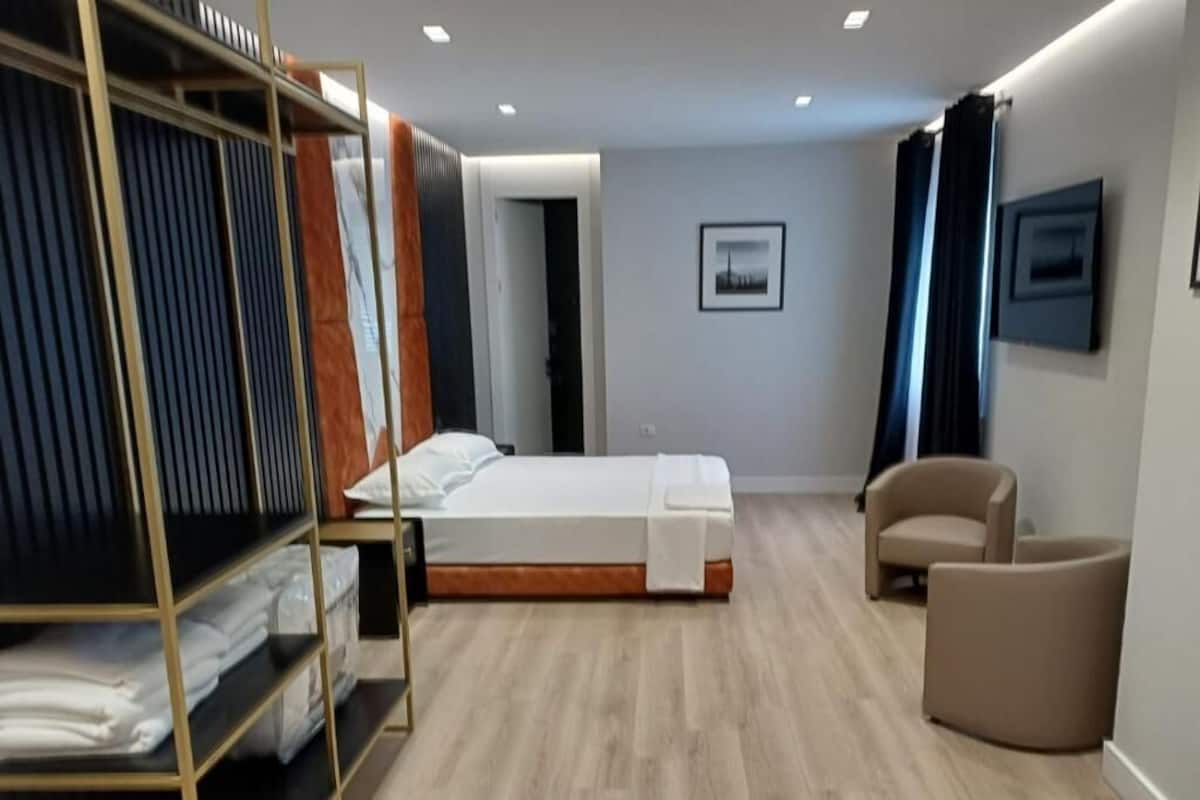 Una habitación de hotel moderna con cama, una silla, un armario y un cuadro en la pared.
