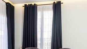 Een moderne kamer met twee fauteuils, een klein rond tafeltje en een witte radiator.