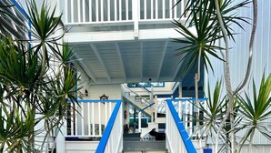 A staircase leading to a building with a blue and white exterior, surrounded by tropical plants and pebbles. - Beautiful ocean view 4-bedroom house with AC in the island of Culebra PR (Culebra)