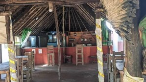 A rustic interior with a thatched roof, wooden furniture, and a red wall. - cocobeach chez antoine avepozo (Lomé)