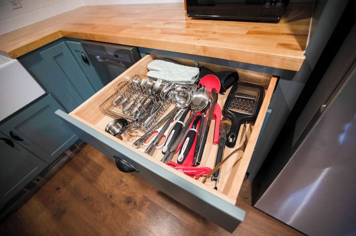 A kitchen drawer with various utensils and kitchen tools.