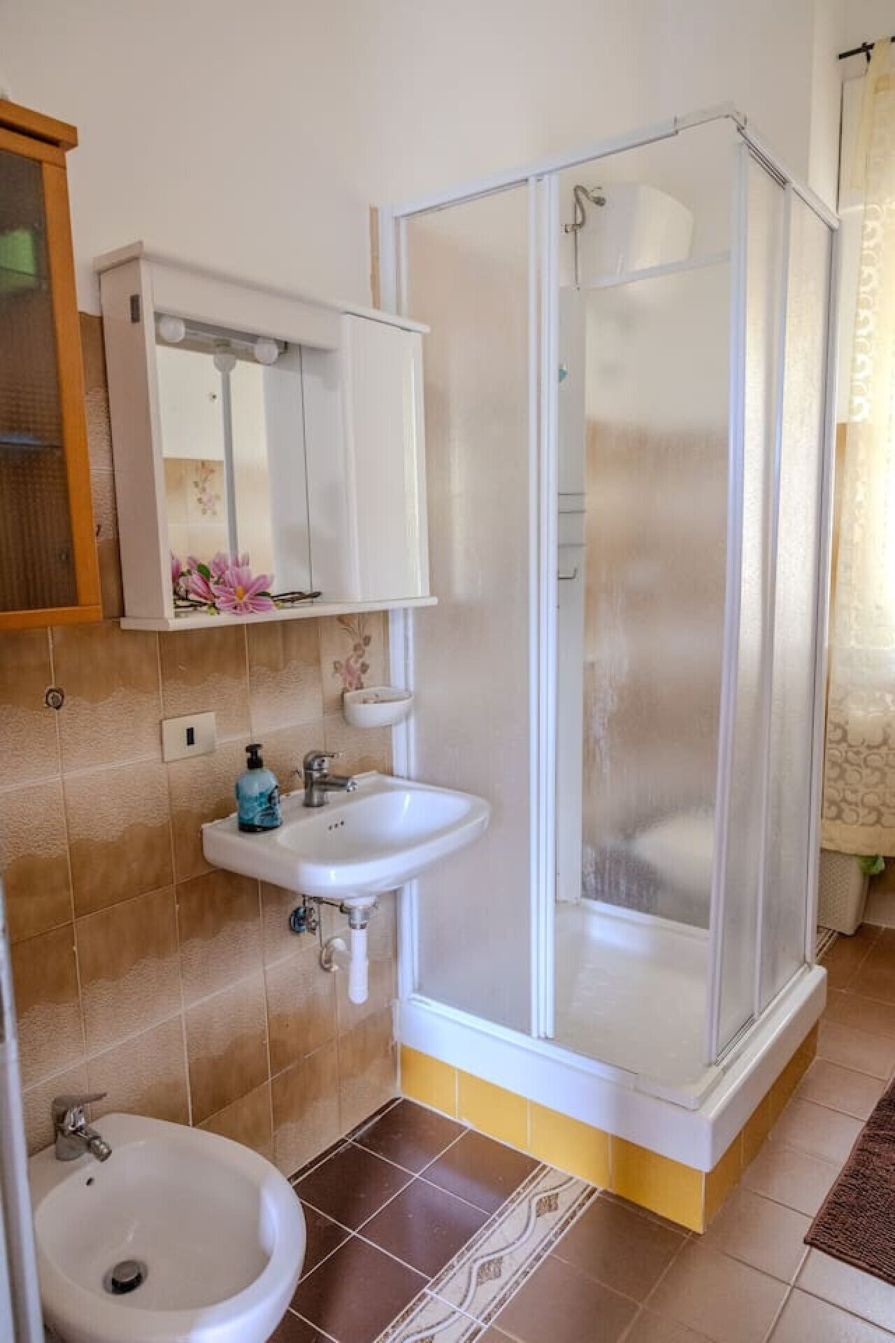 Ein Badezimmer mit Dusche, Waschbecken und Toilette.