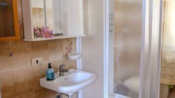 Ein Badezimmer mit Dusche, Waschbecken und Toilette.