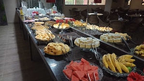 A buffet with various food items including bread, pastries, and fruits like watermelon and bananas. - POUSADA ANGRA BELLA (Angra dos Reis)