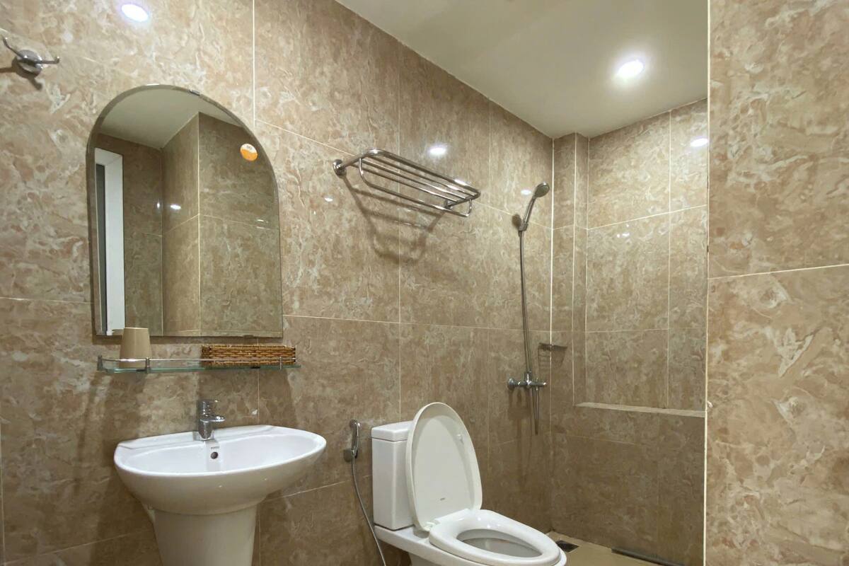 A modern bathroom with a sink, toilet, and shower.
