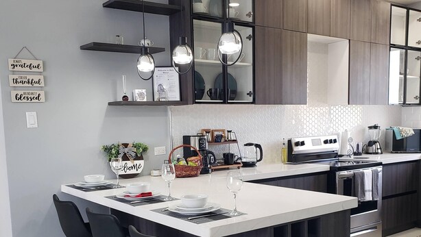A modern kitchen with a central island, bar stools, and a variety of appliances. - MetzManor:Modern luxury Kgn retreat, scenic views,balconies,gated,self check-in  (Kingston)