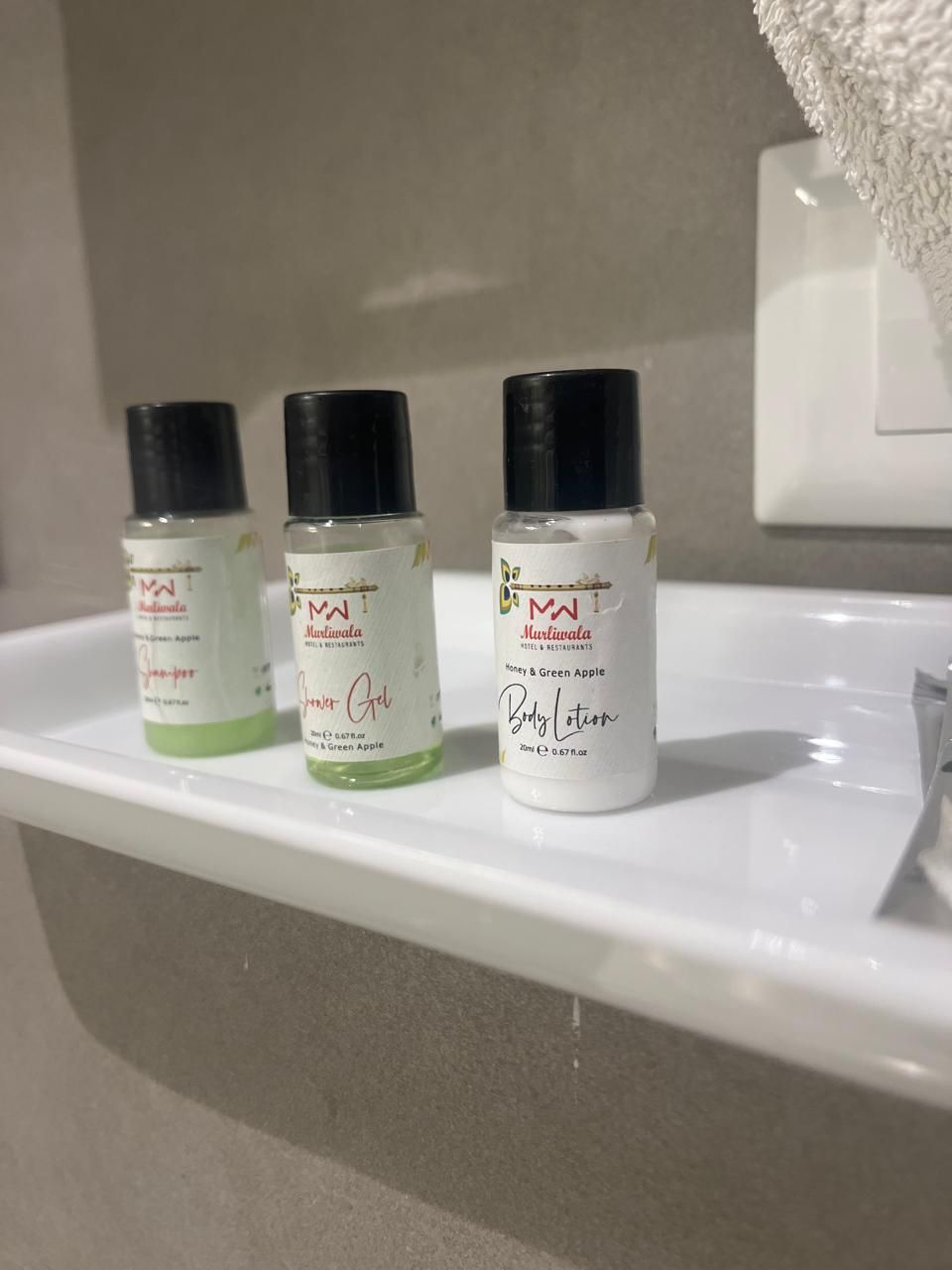 Three bottles of Mustilata products on a bathroom shelf.