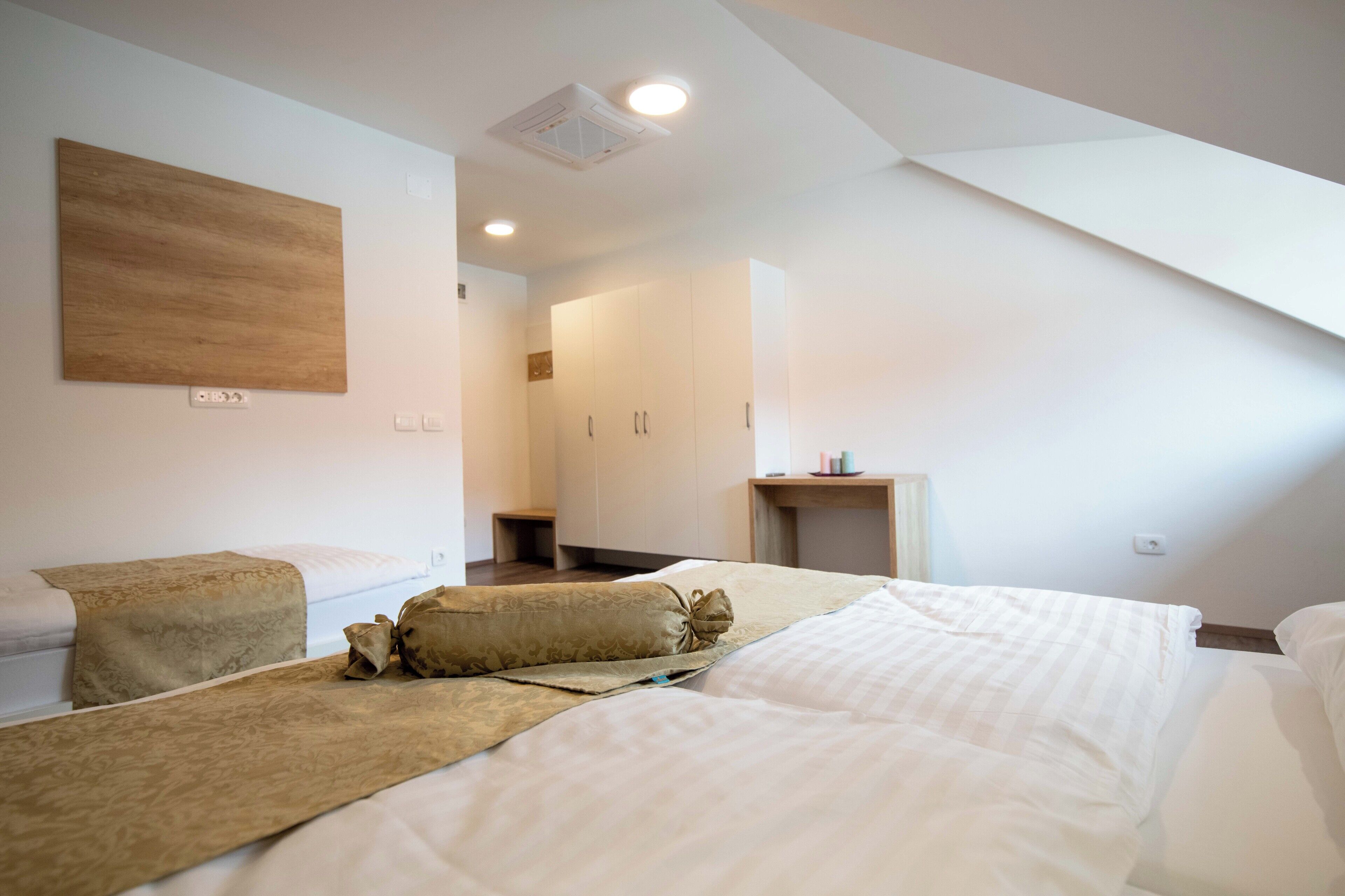 Una habitación de hotel moderna con una cama grande, un escritorio pequeño y un vestidor.