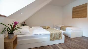 Een moderne loft slaapkamer met een schuine kap, een groot raam en een houten vloer.