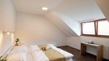 A bedroom with a bed, bedside table, and a window.