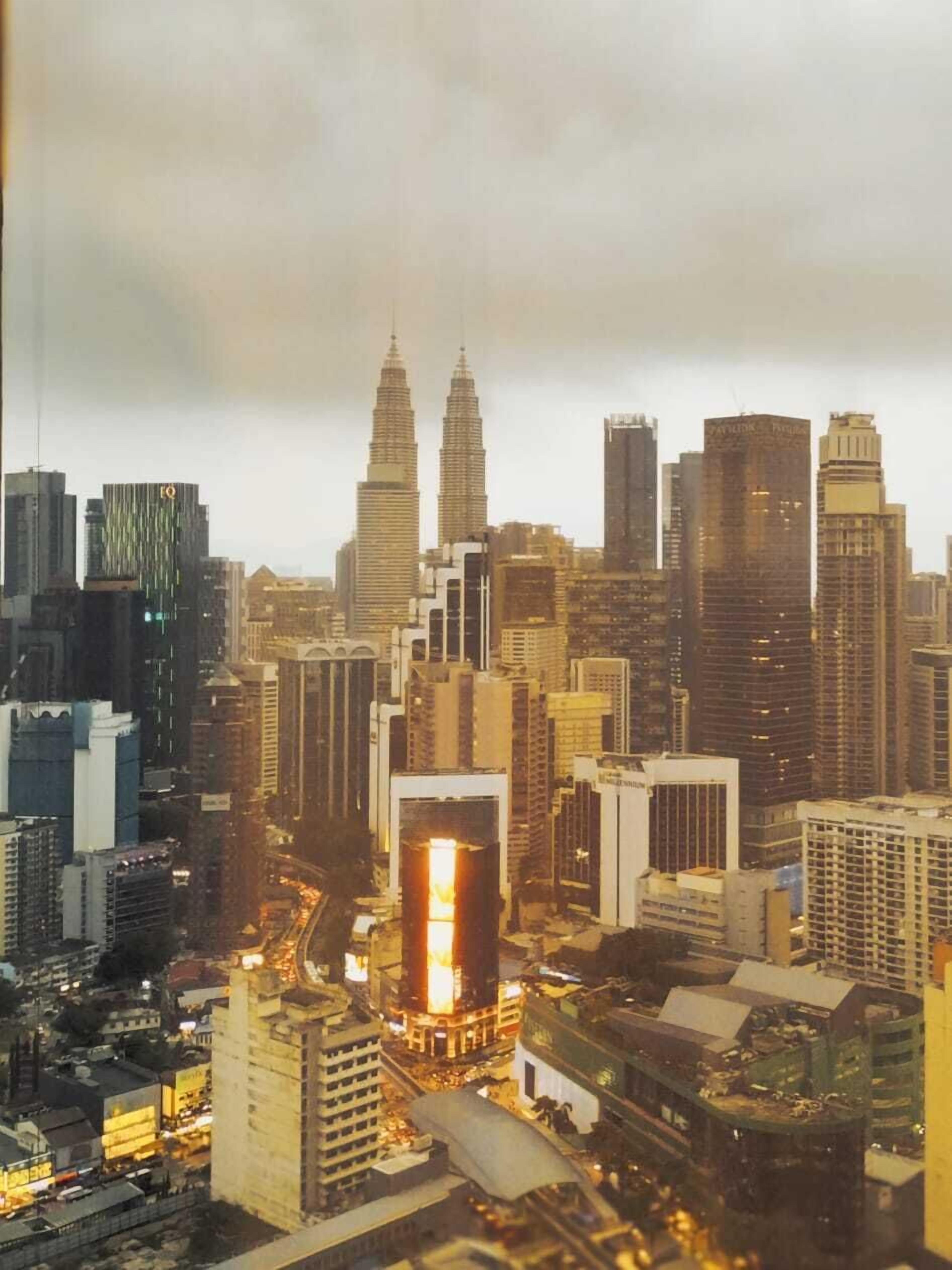 A cityscape with prominent skyscrapers, including two iconic twin towers.