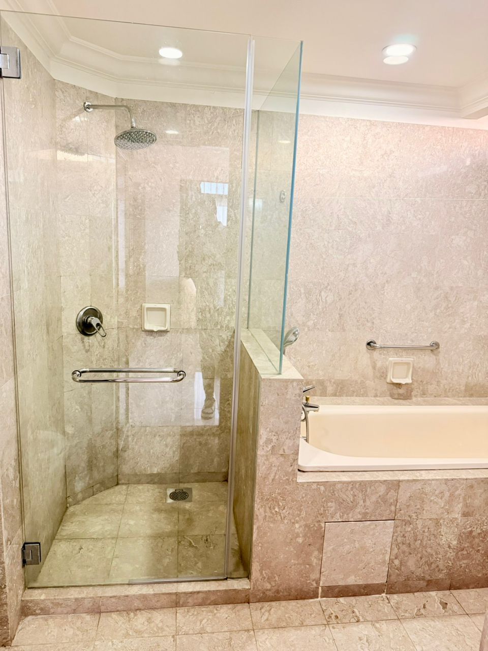 Ein modernes Badezimmer mit einer gläsernen Duschkabine, einer Badewanne und einer Glasdusztür.