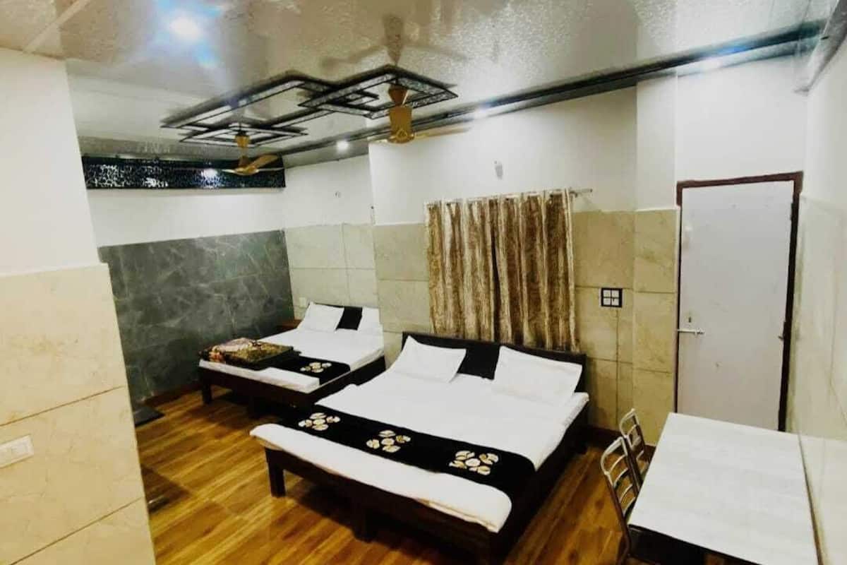 Une chambre d’hôtel avec deux lits, une table et un ventilateur de plafond.